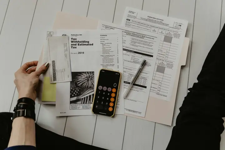 Documente, calculator și pix pe un birou, pregătite pentru verificare